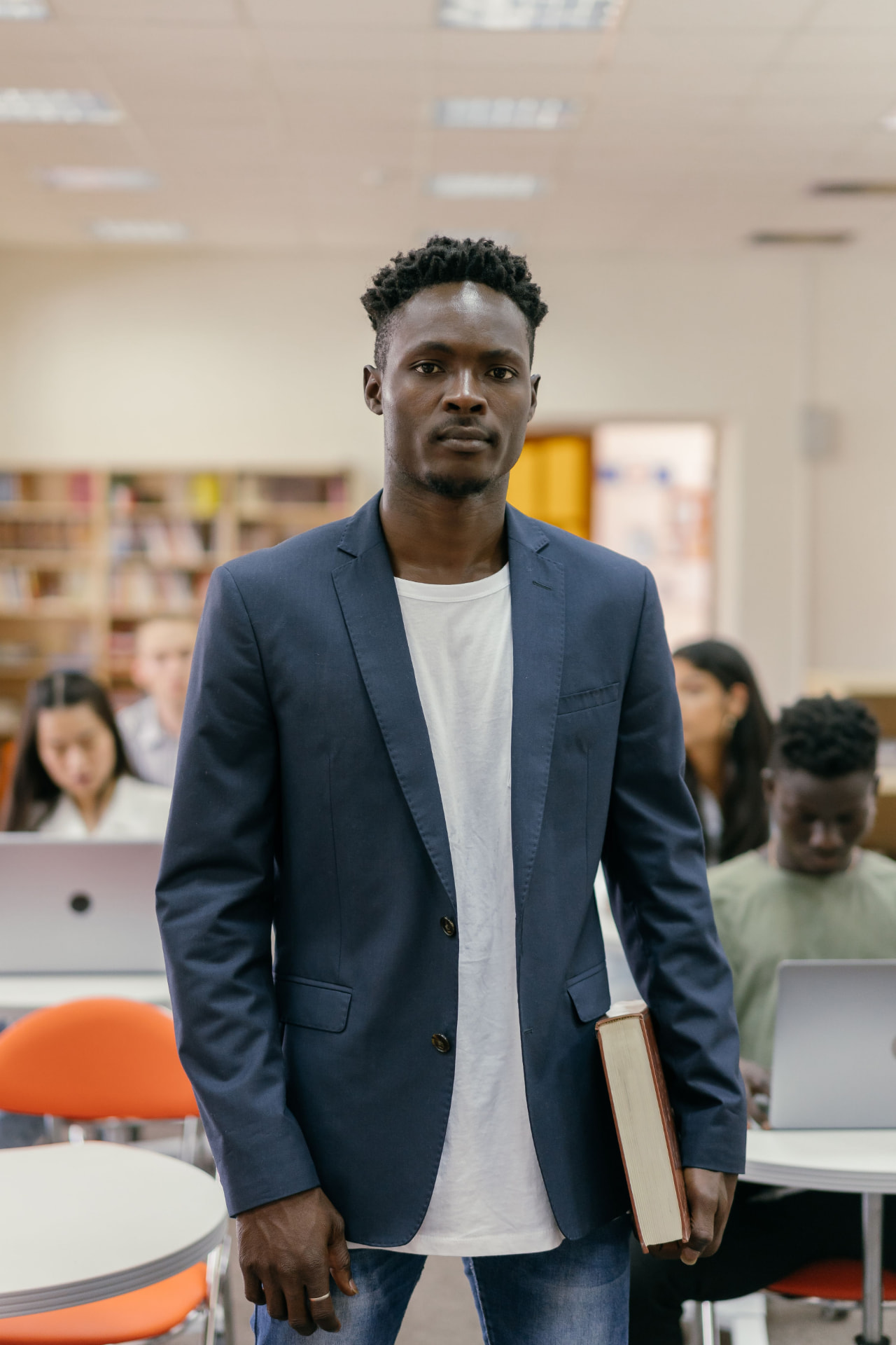 University student holding a book in a campus library