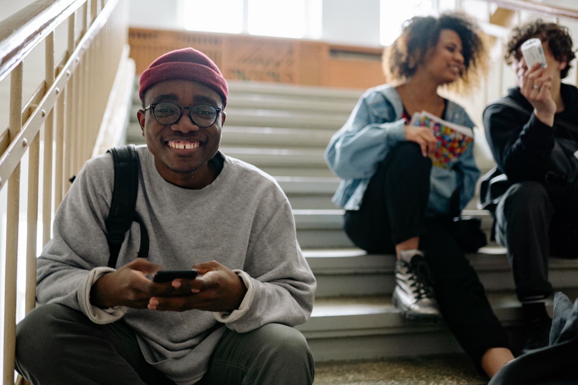 Students smiling together on campus steps between classes